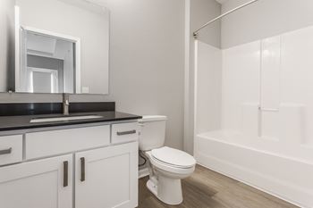 A bathroom with a toilet and a sink and a shower